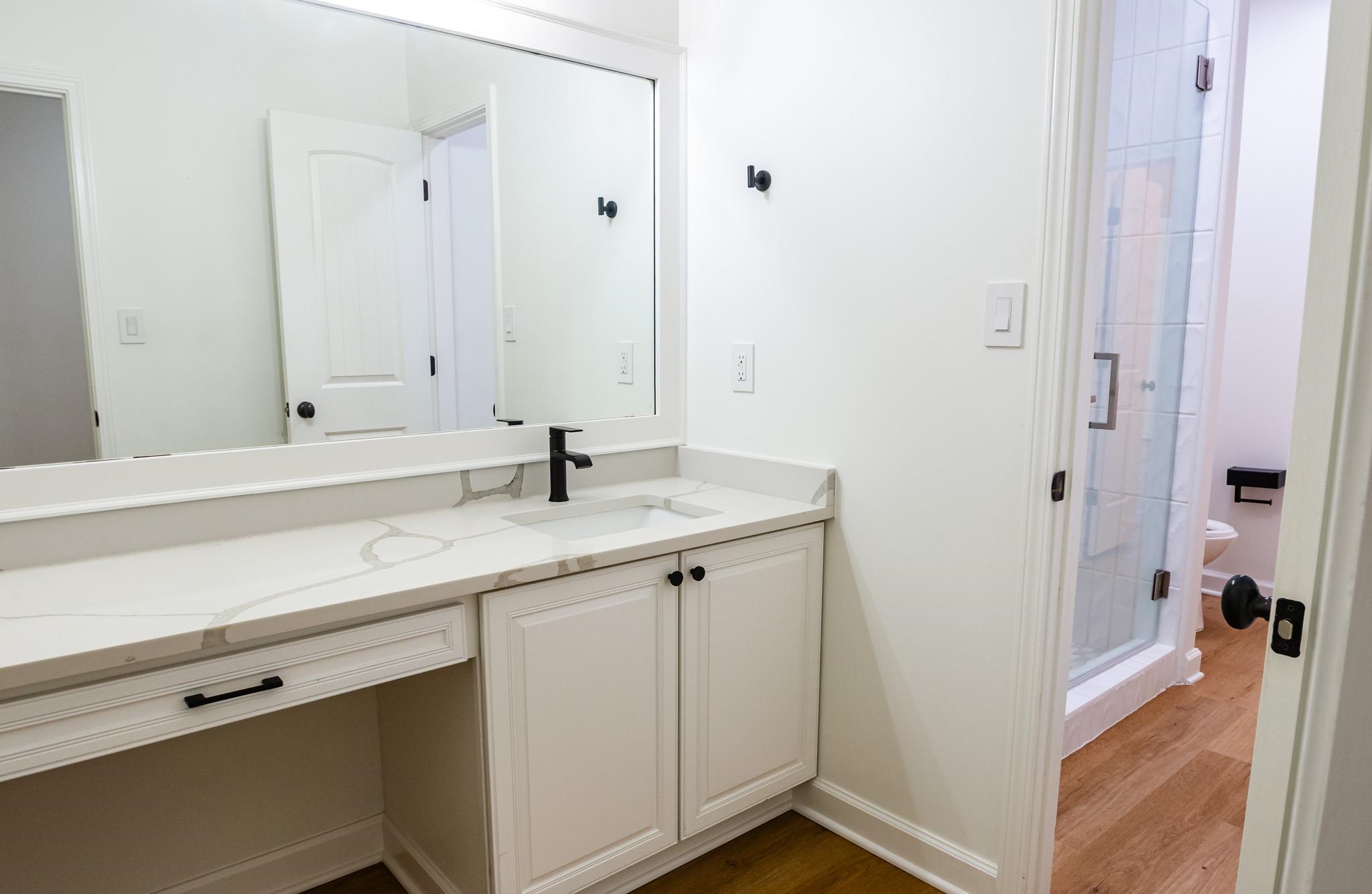 5309 Evergreen Road Lakeland, TN 38002 - Photo 21 of 40 Full bath featuring toilet, vanity, a stall shower, and wood finished floors