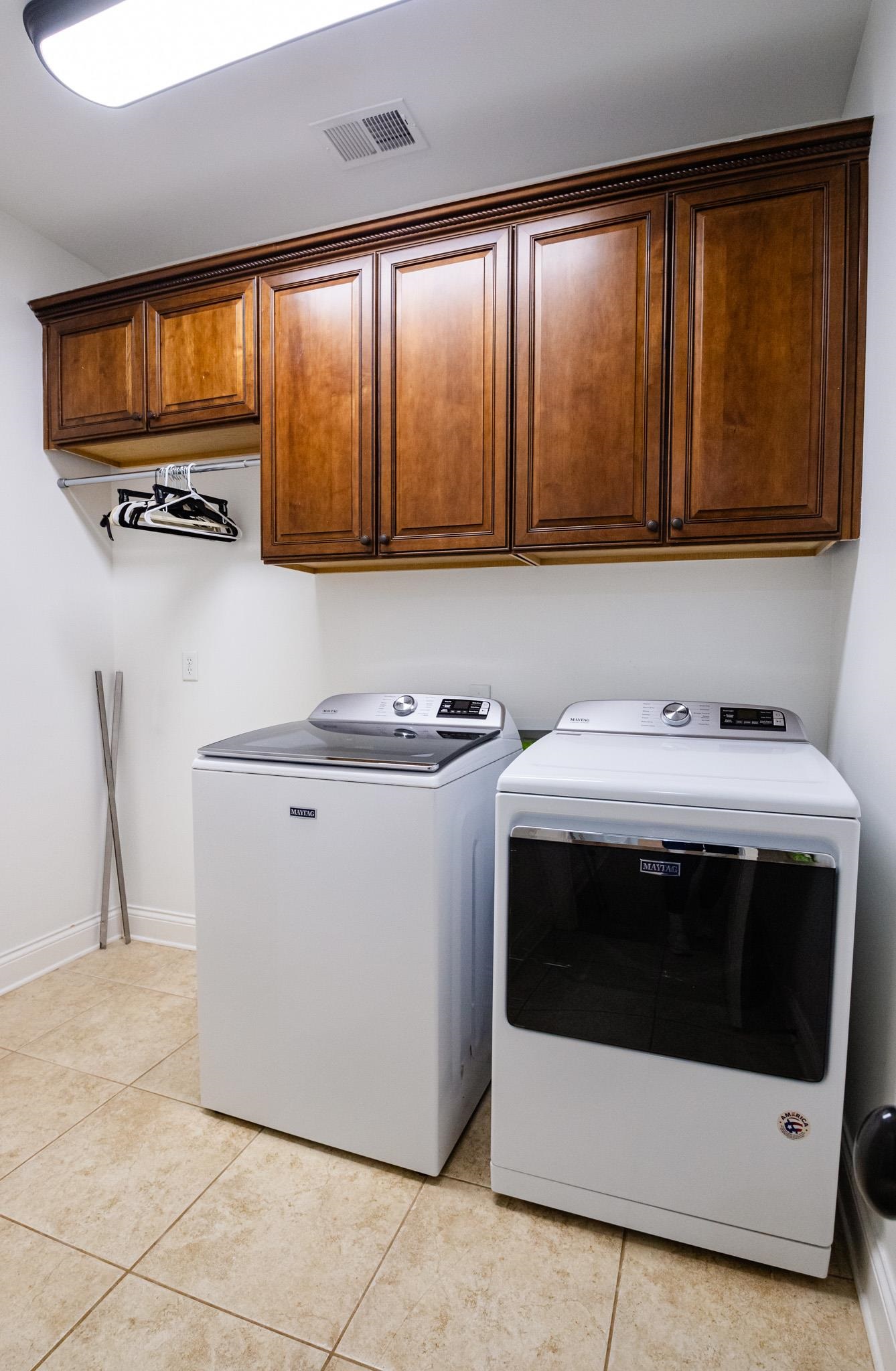5309 Evergreen Road Lakeland, TN 38002 - Photo 24 of 40 Clothes washing area featuring washer and dryer, visible vents, light tile patterned flooring, and cabinet space