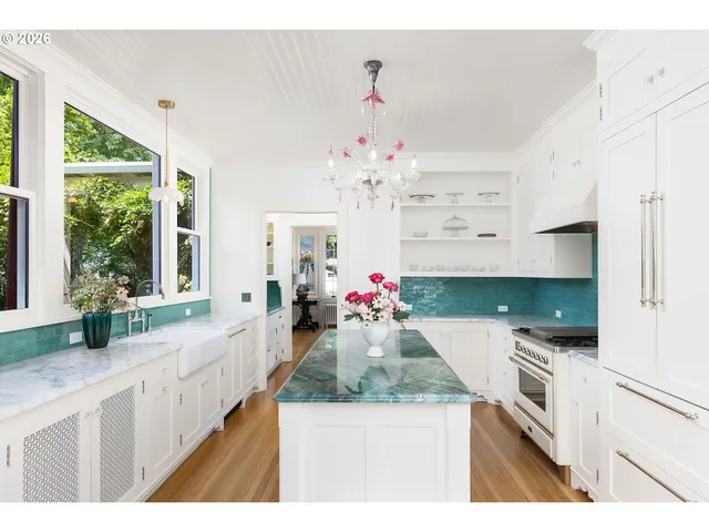 a kitchen with kitchen island granite countertop a stove a large oven a counter top space and living room view