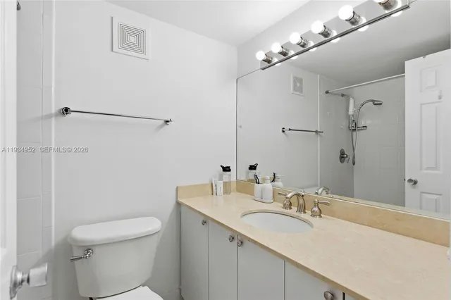 a bathroom with a sink toilet vanity and shower