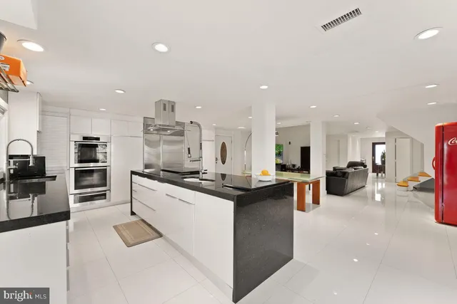 a kitchen with stainless steel appliances kitchen island sink stove and cabinets