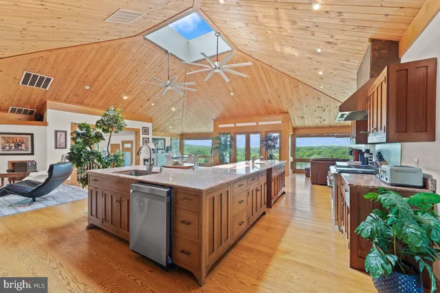 a kitchen with stainless steel appliances granite countertop a stove and a large window