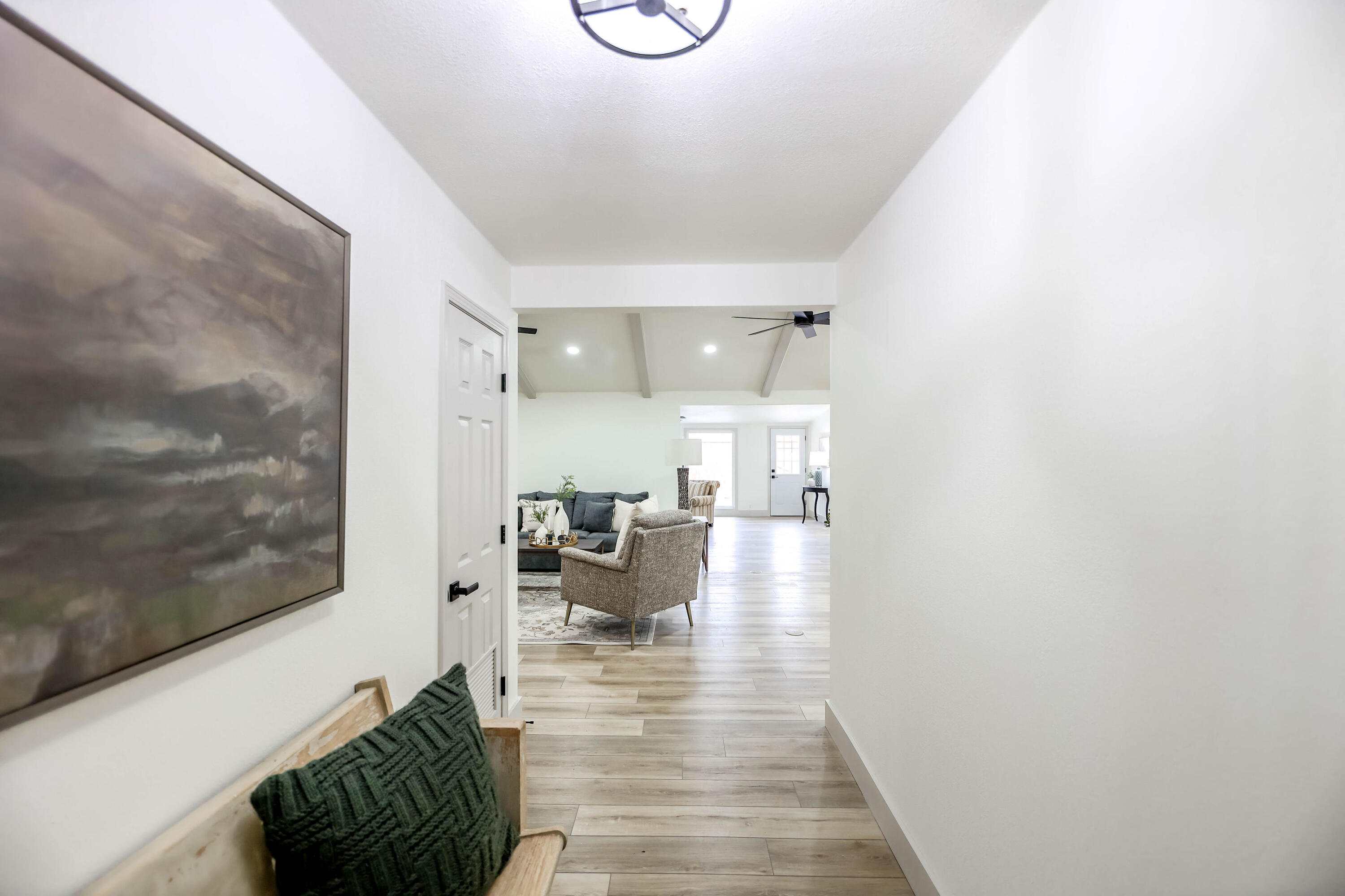 4411 79th Street Lubbock, TX 79424 - Photo 4 of 42 a hallway with a couch and chandelier