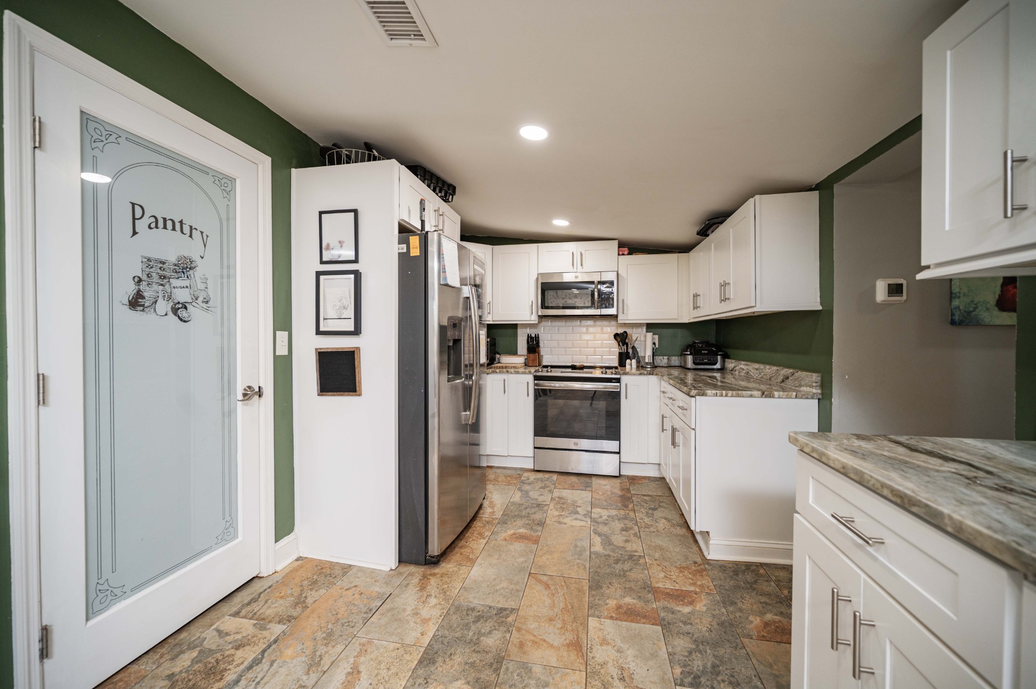 9202 Link Road Christiana, TN 37037 - Photo 13 of 37 a kitchen with white cabinets and stainless steel appliances