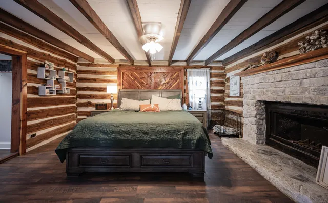 a bedroom with a bed a fireplace and a chandelier