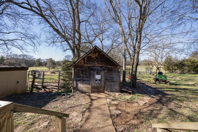 a front view of a house with a yard covered with snow and trees