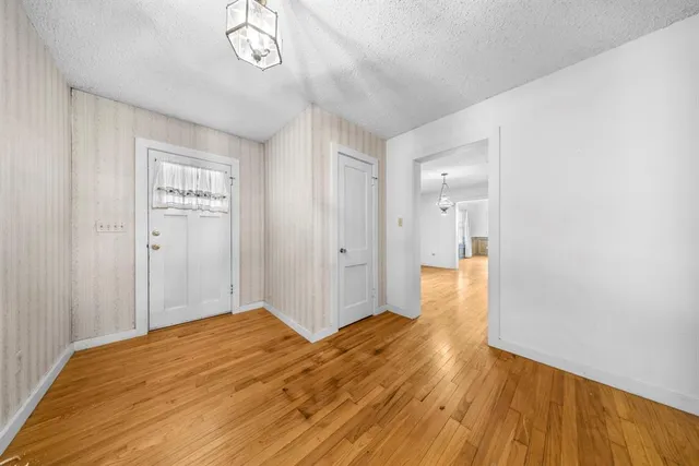a view of a big room with wooden floor and windows