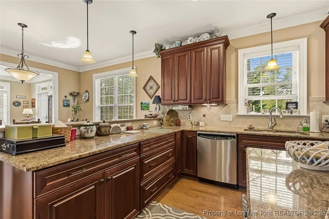 a kitchen with stainless steel appliances granite countertop a sink stove and cabinets