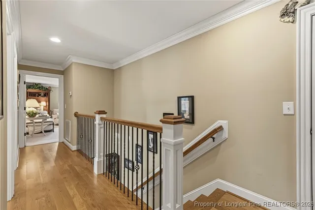 a view of a hallway with wooden floor and stairs