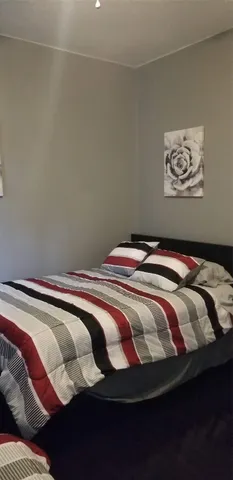 a bedroom with a bed and a painting on the wall