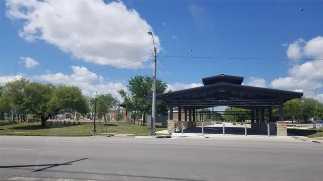 a view of a house with a yard and table and chairs under an umbrella