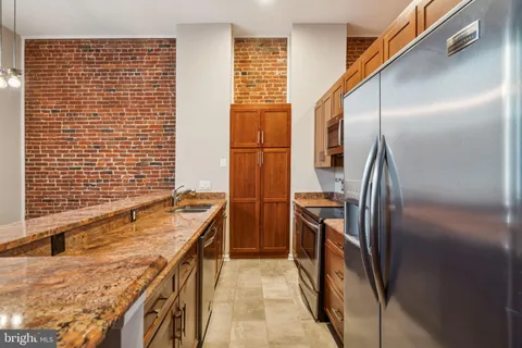 a bathroom with a granite countertop sink and washing machine