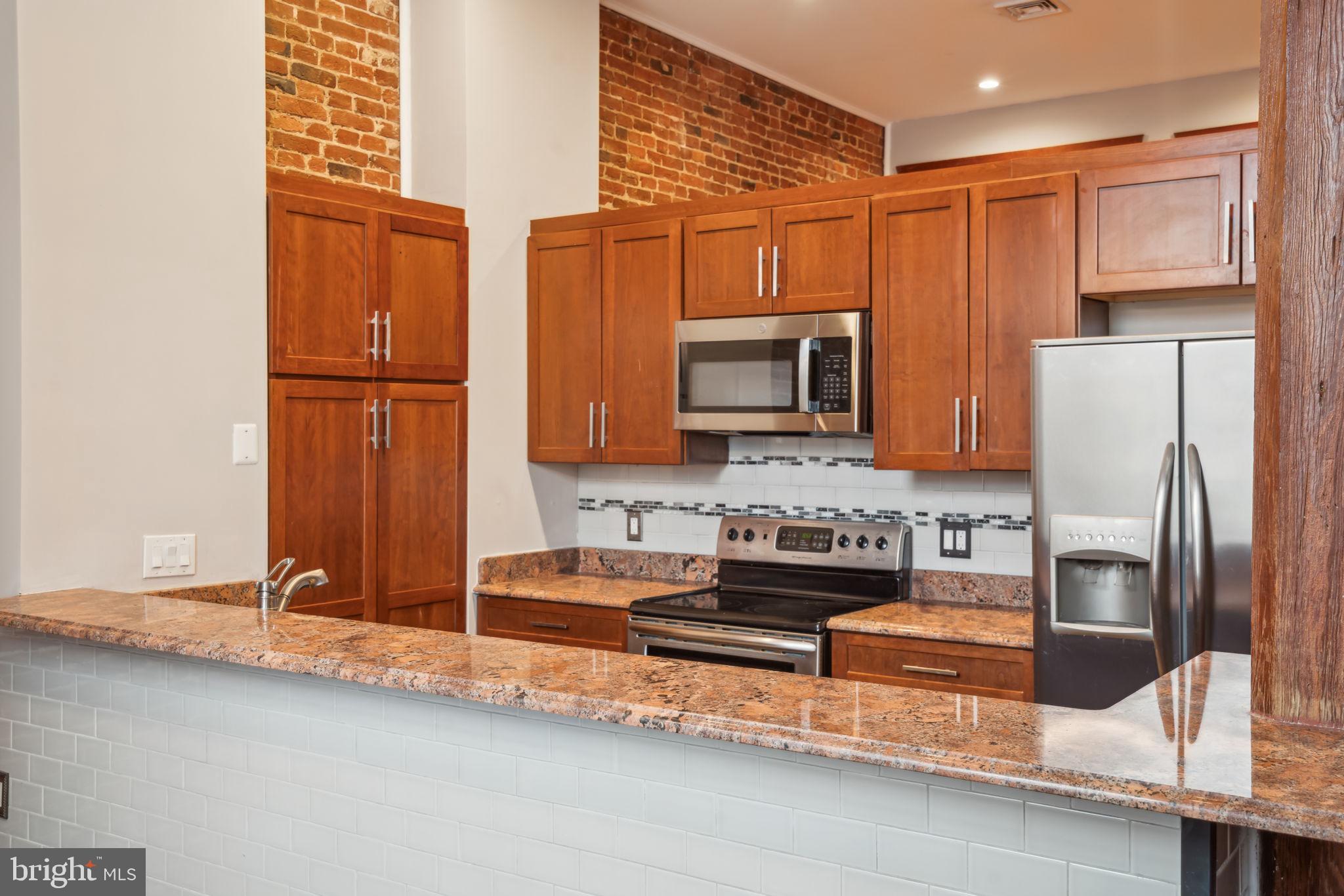 12 Letitia Street, Unit 201 Philadelphia, PA 19106 - Photo 13 of 30 a kitchen with stainless steel appliances granite countertop a refrigerator and a sink