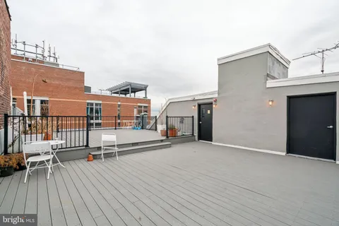 a view of roof deck with table and chairs