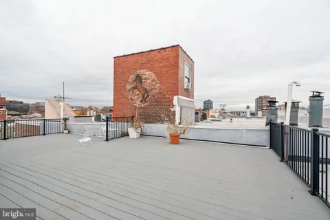 a view of roof deck with table and chairs