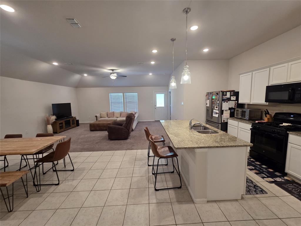 1512 Springtree Drive McKinney, TX 75071 - Photo 4 of 23 a kitchen with stainless steel appliances kitchen island granite countertop a sink and a stove
