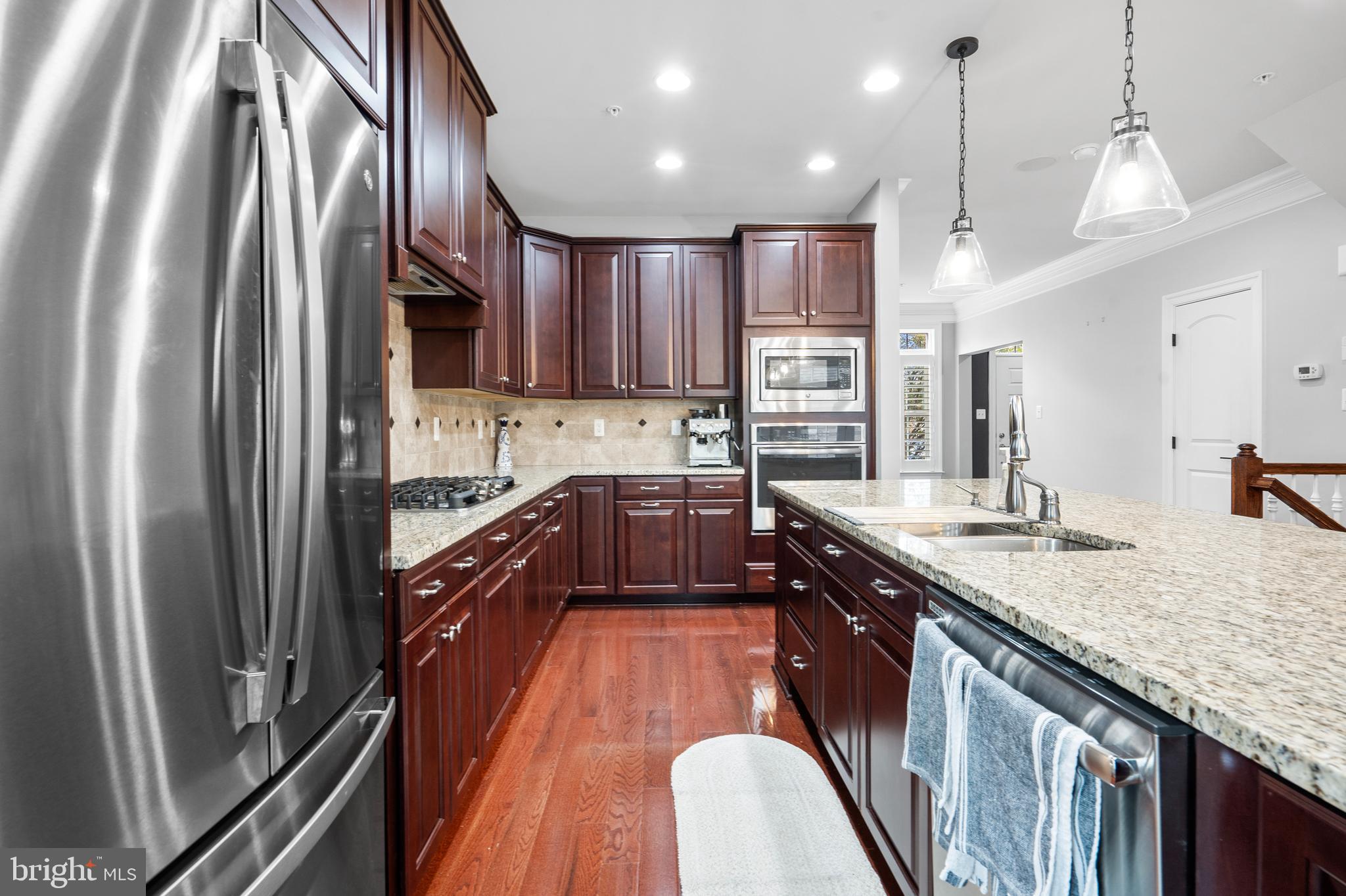 3822 Jacob Stout Road Doylestown, PA 18902 - Photo 19 of 39 a kitchen with stainless steel appliances granite countertop a refrigerator a sink dishwasher a stove and white countertops with wooden floor