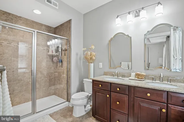 a bathroom with a double vanity sink toilet and shower