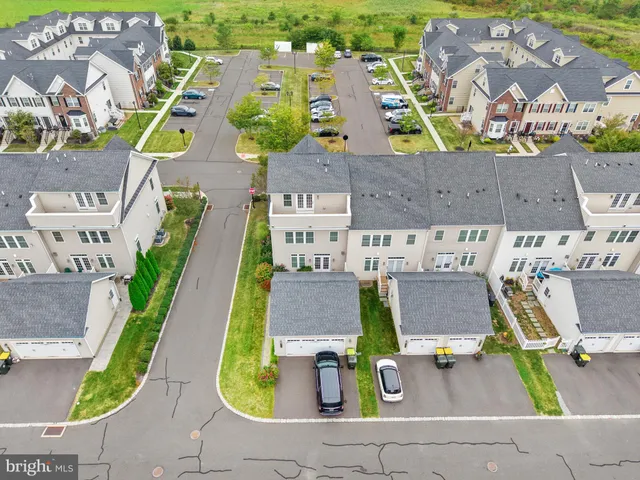 an aerial view of residential houses with outdoor space and parking