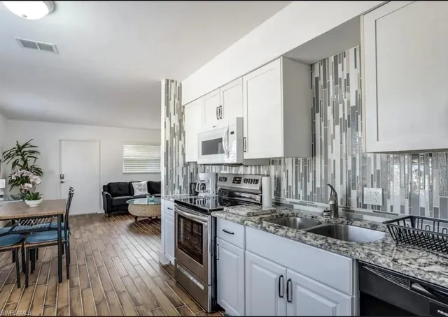 a kitchen with stainless steel appliances granite countertop a stove and a sink