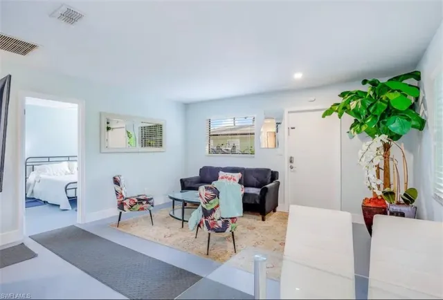 a living room with furniture a potted plant and a table