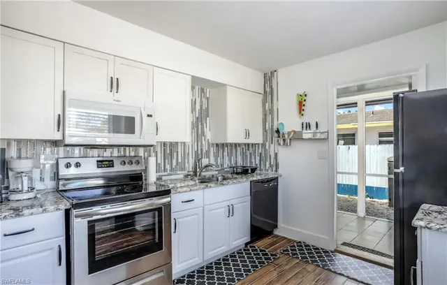 a kitchen with stainless steel appliances a stove a refrigerator and a sink