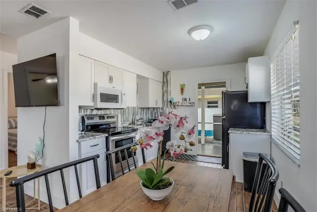 a kitchen with stainless steel appliances kitchen island granite countertop a refrigerator stove top oven a sink and dishwasher