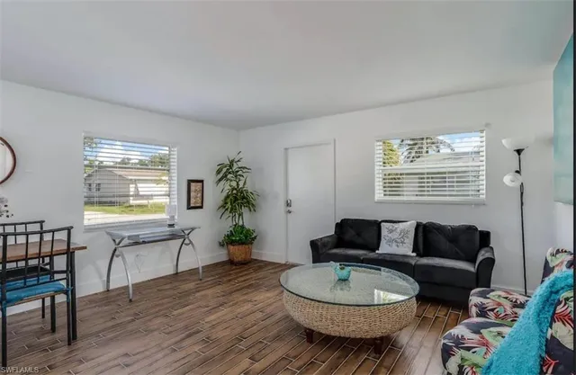 a living room with furniture a potted plant and a window