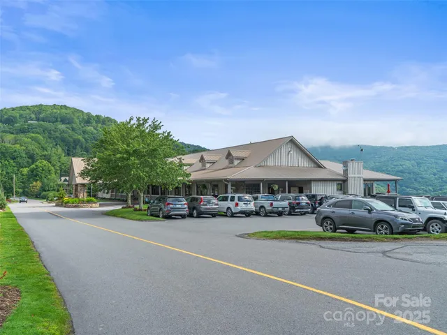 a view of pool with lawn chairs and plants