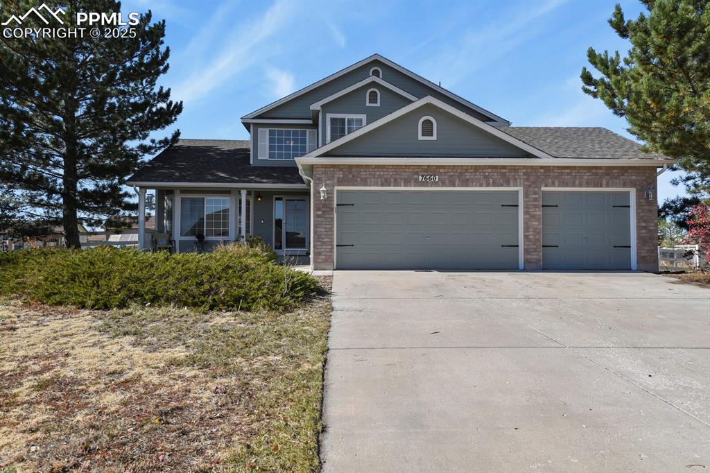 7660 Bullet Road Peyton, CO 80831 - Photo 1 of 50 a front view of a house with a yard and garage