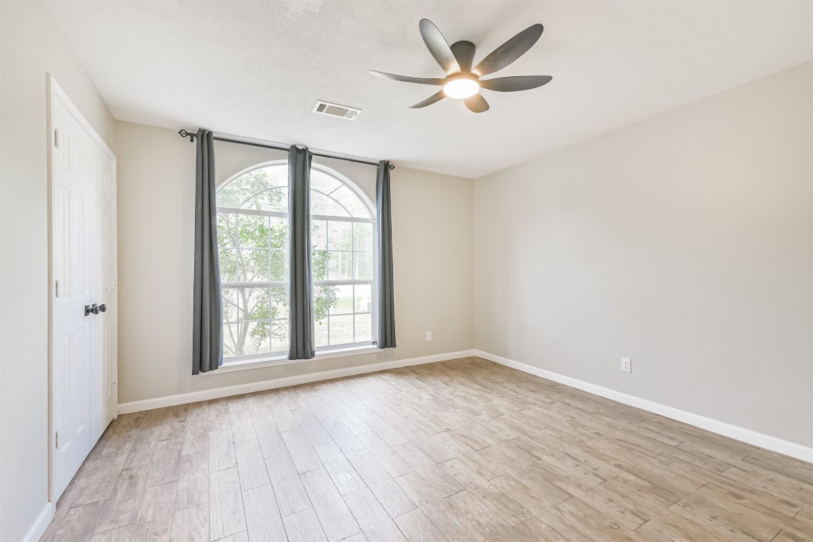 16468 Ryan Guinn Way Conroe, TX 77303 - Photo 24 of 31 an empty room with wooden floor and windows