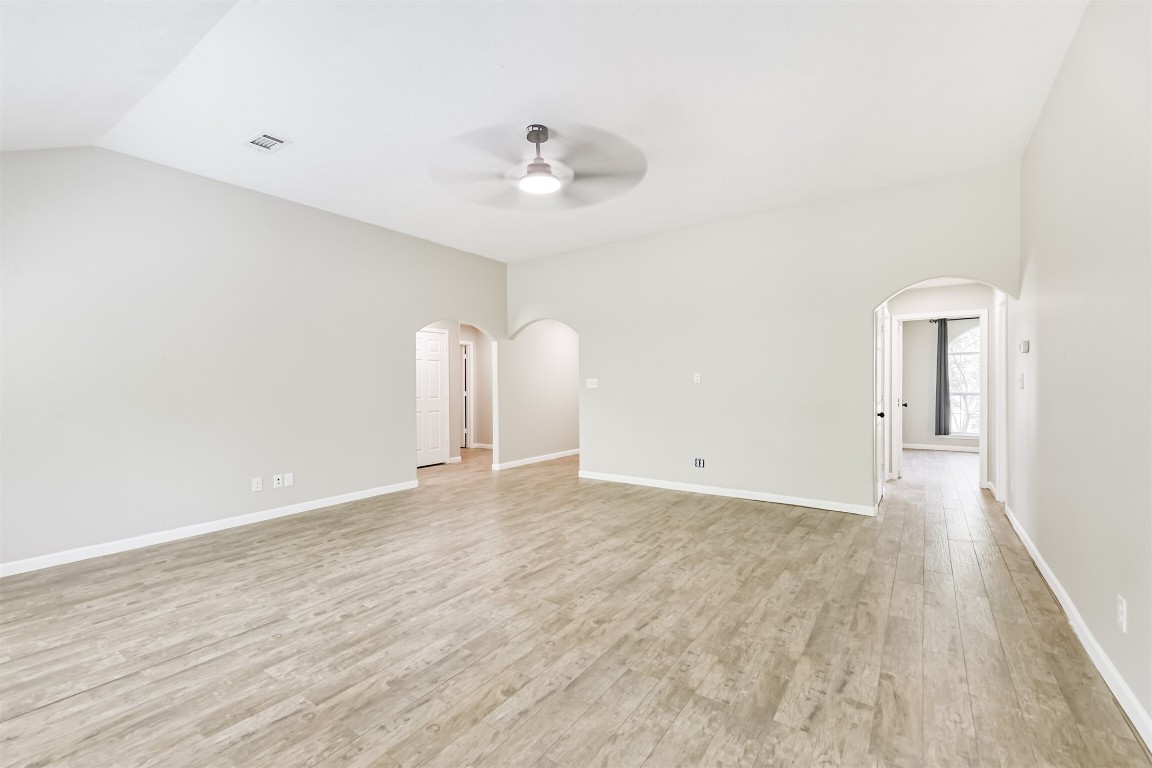 16468 Ryan Guinn Way Conroe, TX 77303 - Photo 6 of 31 a view of an empty room with wooden floor and a ceiling fan