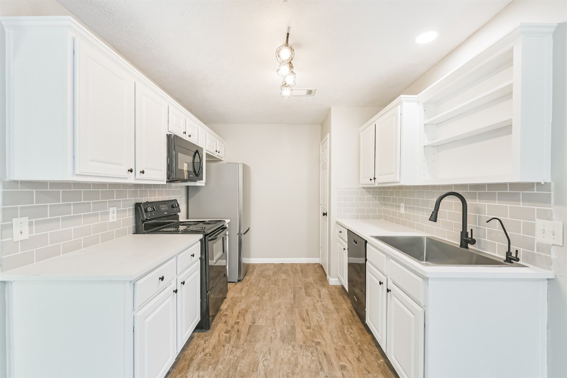 16468 Ryan Guinn Way Conroe, TX 77303 - Photo 8 of 31 a kitchen with sink a stove and cabinets