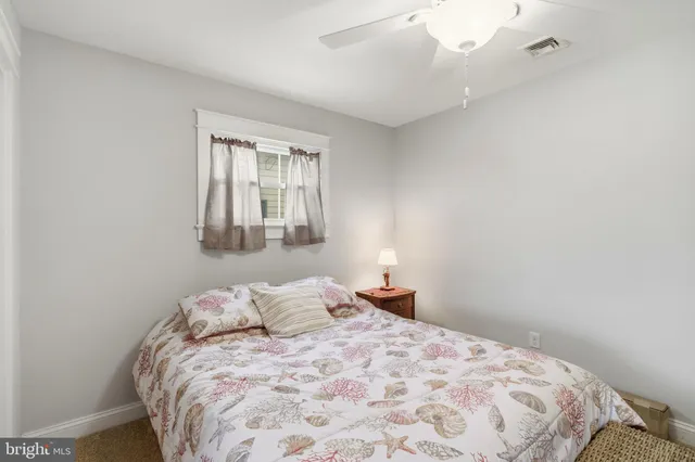 a bedroom with a bed and a chandelier fan
