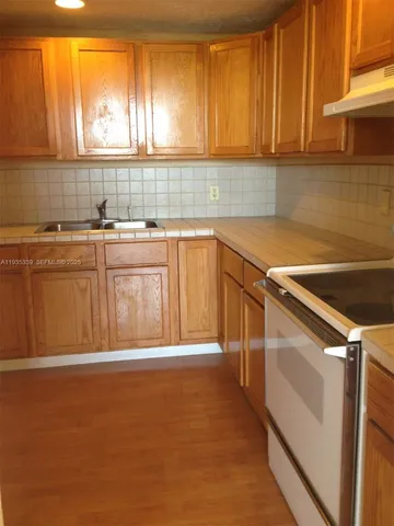 a kitchen with a sink a stove and cabinets
