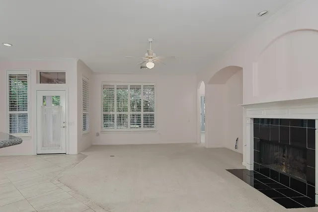 an empty room with windows and fireplace