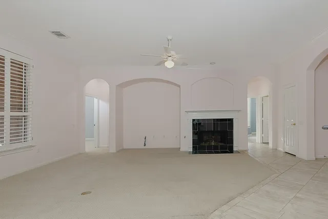 an empty room with windows and fireplace