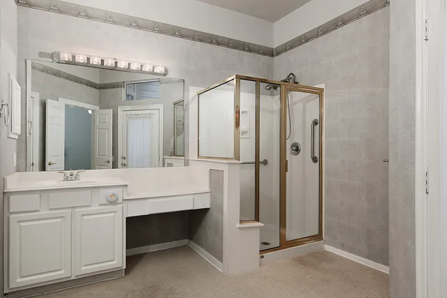 a bathroom with a double vanity sink a mirror and a shower
