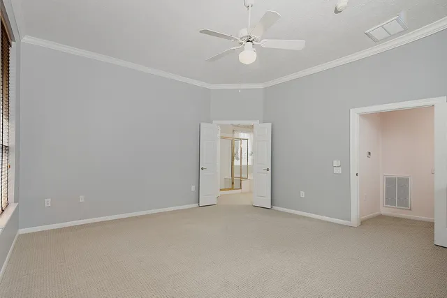an empty room with a ceiling fan and a window