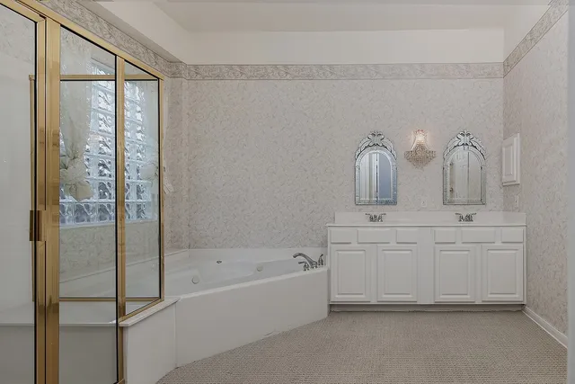 a bathroom with a bathtub sink vanity and mirror