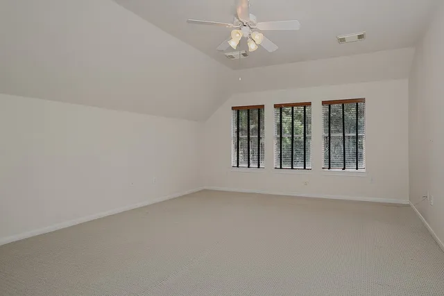 an empty room with chandelier fan