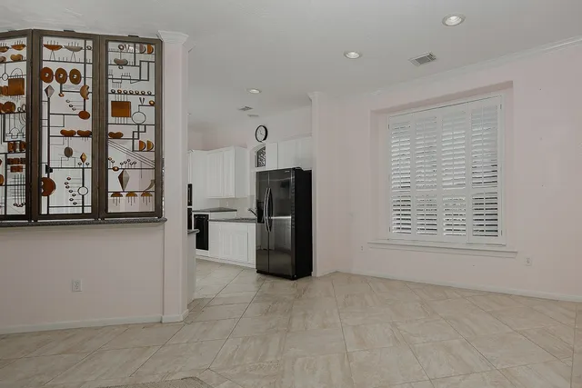 a view of a kitchen with refrigerator and more cabinets