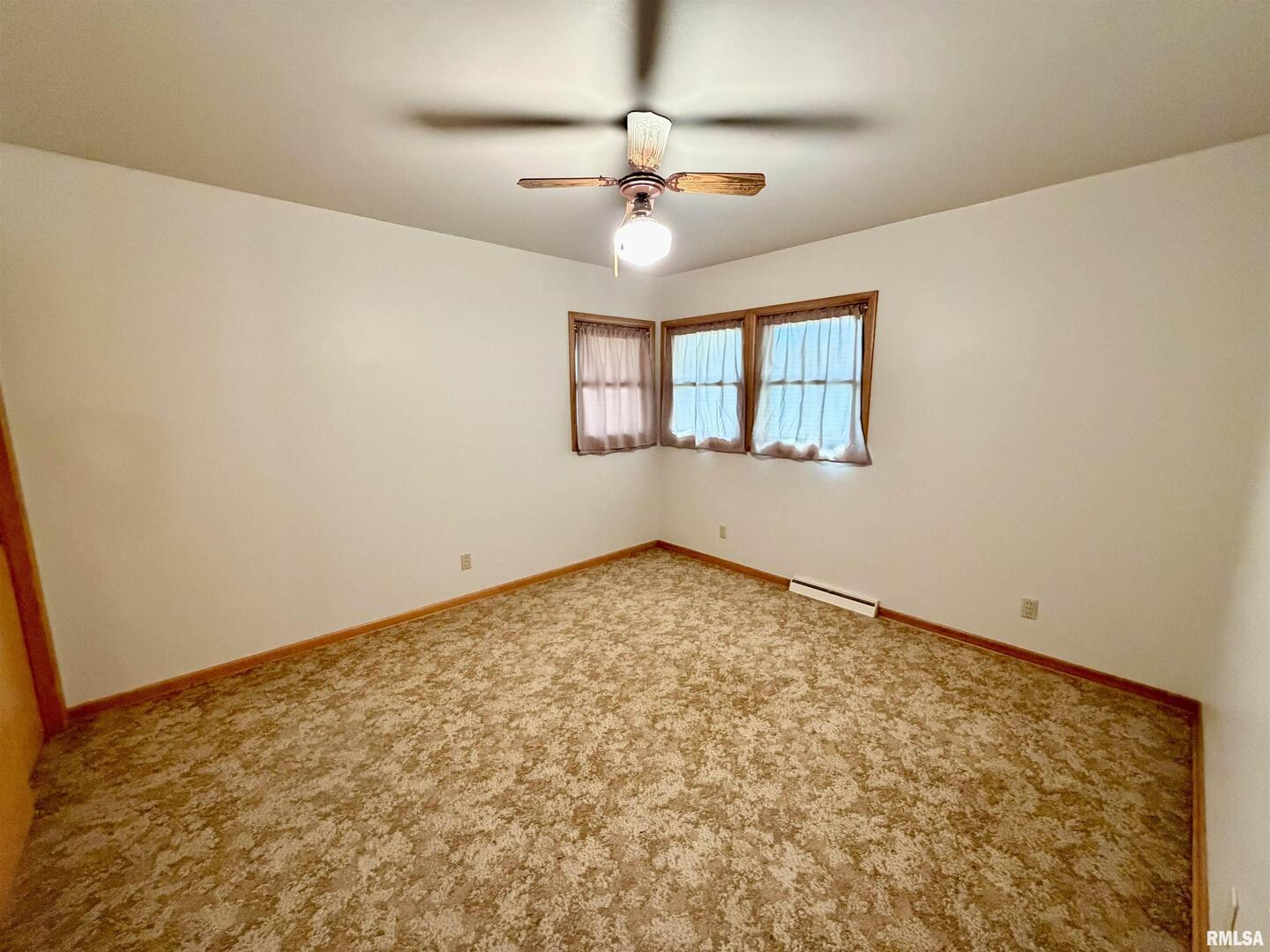 712 3rd Street Seaton, IL 61476 - Photo 7 of 15 an empty room with a ceiling fan and window