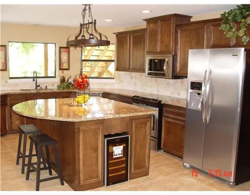 a kitchen with stainless steel appliances a sink a microwave a refrigerator and wooden floor