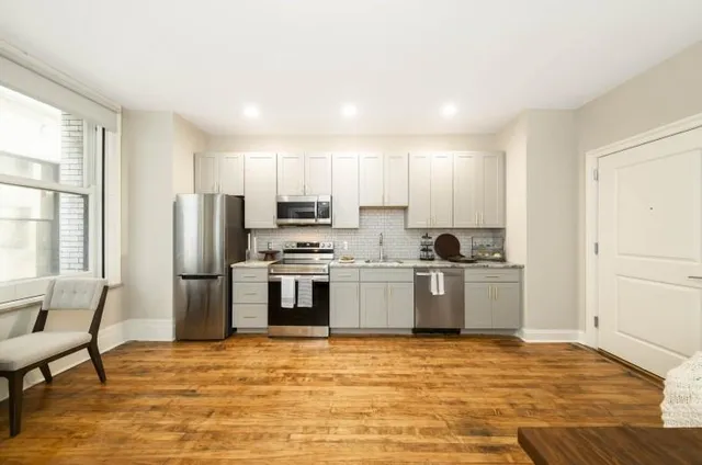 a kitchen with a refrigerator and a stove top oven