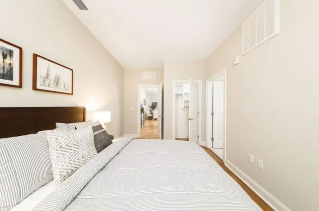 a bedroom with a large bed and a chandelier