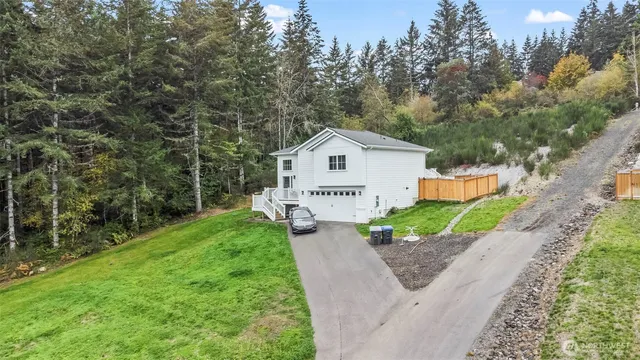 a view of a house with a yard and large tree