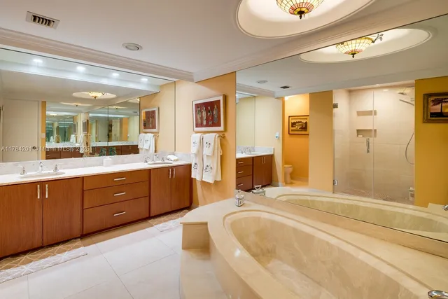 a spacious bathroom with a tub sink shower and mirror