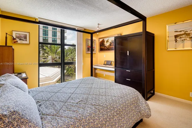 a bedroom with a bed and a dresser next to a window