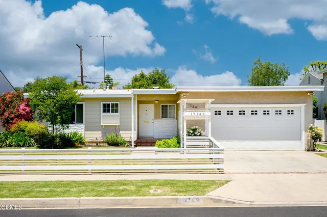 a front view of a house with a garden and plants
